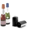 Bouchon-pince noir Pulltex présenté avec des bouteilles de vin effervescent