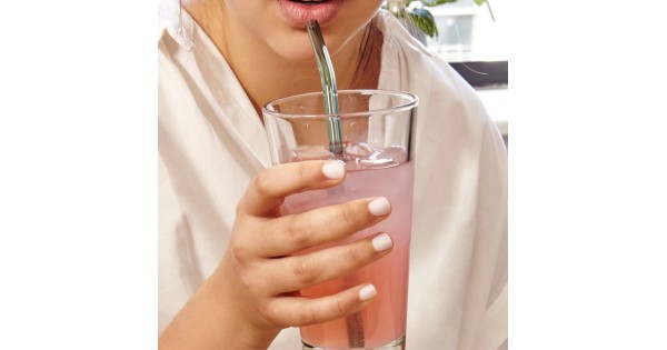 Paille en verre Kikkerland utilisée dans un verre de boisson rose