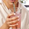 Paille en verre Kikkerland utilisée dans un verre de boisson rose
