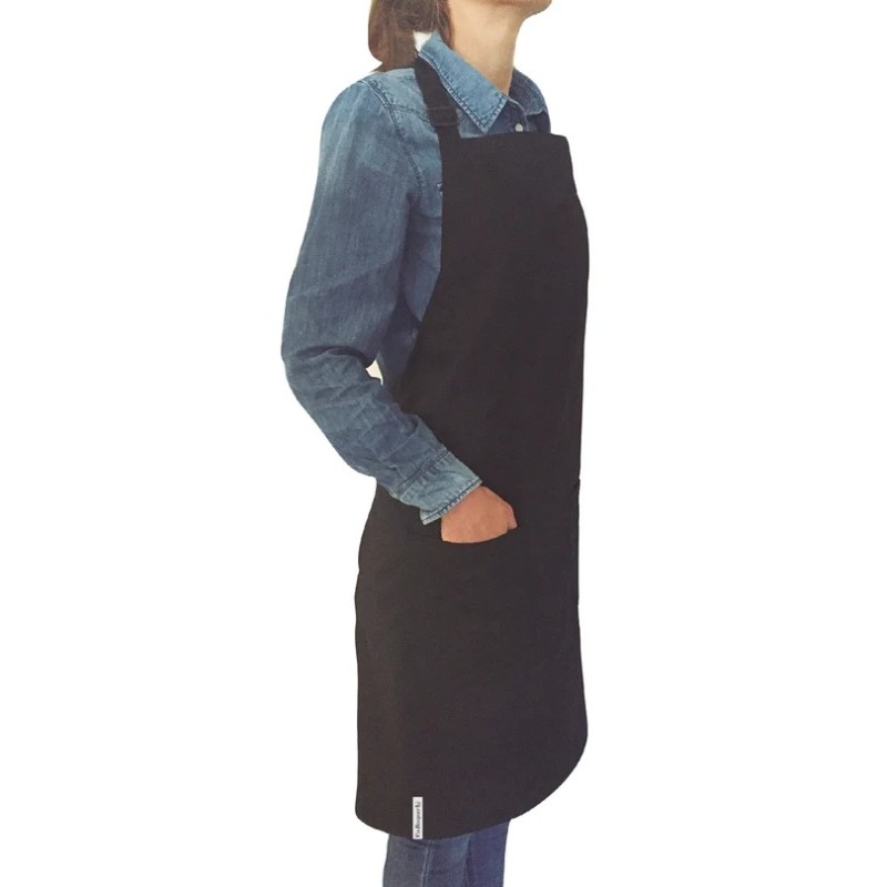 Tablier noir à deux poches porté sur une chemise