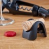 Coupe-capsule Vacu Vin utilisé comme porte-bouchon sur la table