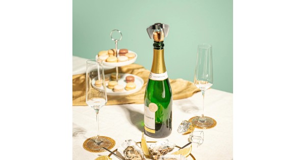 Griffe Vacu Vin placée sur une bouteille de champagne à table