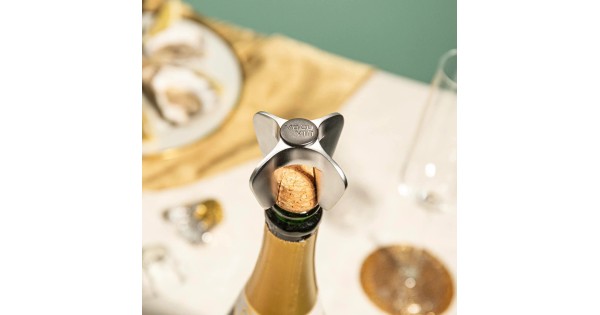 Griffe Vacu Vin autour du bouchon d’une bouteille de champagne