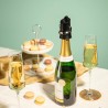 Bouchon garde-champagne Vacu Vin posé sur une bouteille à table