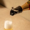 Service du champagne dans une flûte avec le bouchon verseur Vacu Vin