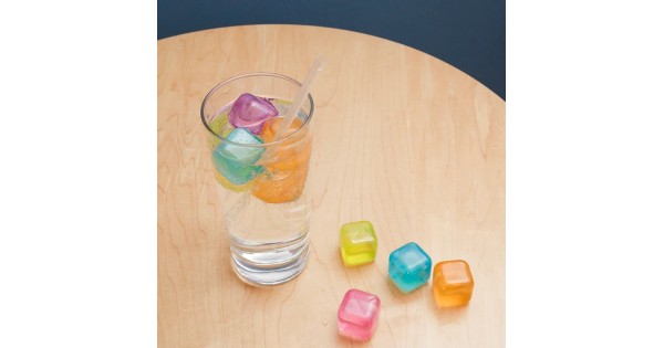 Glaçons réutilisables colorés Kikkerland dans un verre et sur la table