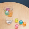 Glaçons réutilisables colorés Kikkerland dans un verre et sur la table