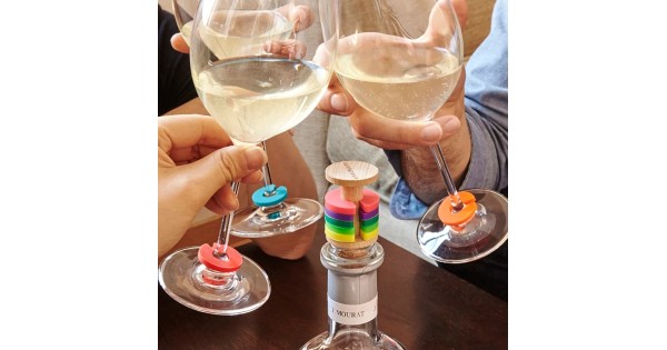 Marque-verres colorés Kikkerland sur des verres à pied pendant un apéritif