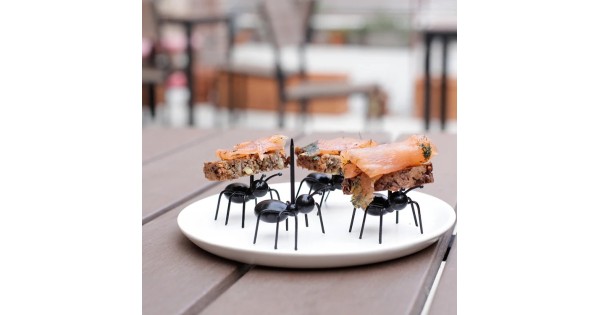 Pics apéritifs Fourmis Kikkerland portant des bouchées sur une assiette