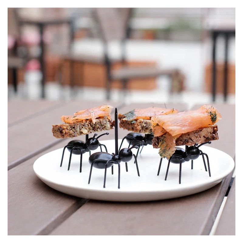 Pics apéritifs Fourmis Kikkerland portant des bouchées sur une assiette