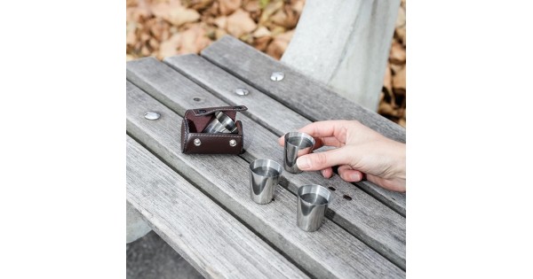 Petits verres inox Kikkerland et étui présentés sur une table extérieure