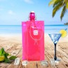 Sac rafraîchisseur Ice.Bag Classic rose Pink avec une bouteille dans un décor de plage