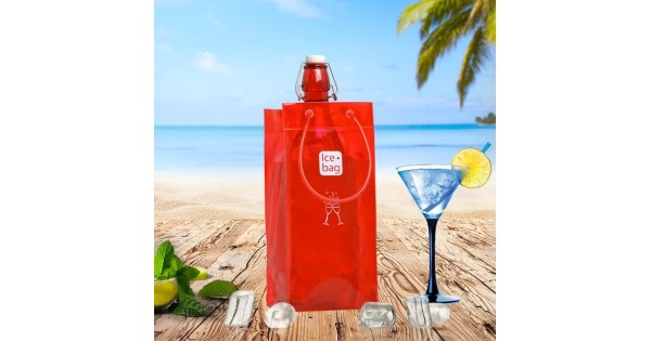 Sac rafraîchisseur Ice.Bag Classic rouge cerise Cherry Red avec une bouteille dans un décor de plage