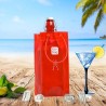 Sac rafraîchisseur Ice.Bag Classic rouge cerise Cherry Red avec une bouteille dans un décor de plage