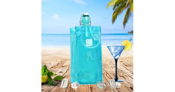 Sac rafraîchisseur Ice.Bag Classic bleu clair Frost Blue avec une bouteille dans un décor de plage