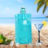 Sac rafraîchisseur Ice.Bag Classic bleu clair Frost Blue avec une bouteille dans un décor de plage