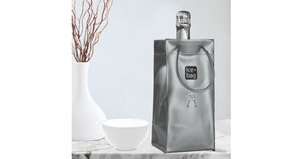 Sac Ice.Bag Classic argent mat présenté à table avec une bouteille et une flûte