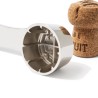 Détail des mâchoires de la pince L’Atelier du Vin à côté d’un bouchon de champagne