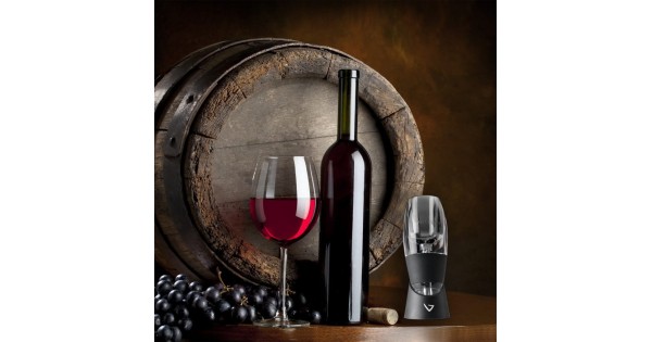 Aérateur Classic Vinturi et verre de vin rouge présentés devant un tonneau
