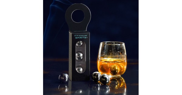 Glaçons boules Titanium Spirits avec leur boîte à côté d’un verre de whisky
